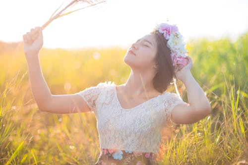 Femme Debout Au Milieu Du Champ D'herbe Tient Sa Tête Tout En Lui Prenant Une Photo