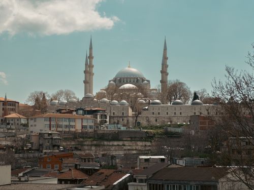 Free View of the stunning Suleymaniye Mosque standing prominently over Istanbul's cityscape, under a bright daytime sky. Stock Photo