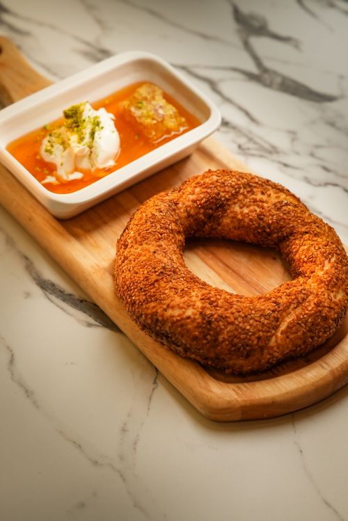 Free Delicious Turkish simit served with rich Aegean breakfast spread on a marble countertop. Stock Photo