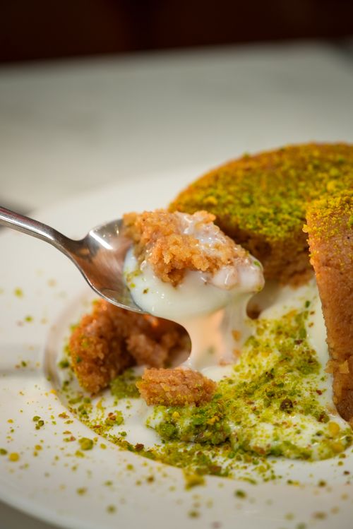 Free Savory spoon of Middle Eastern semolina cake with pistachios, drizzled in syrup. Stock Photo