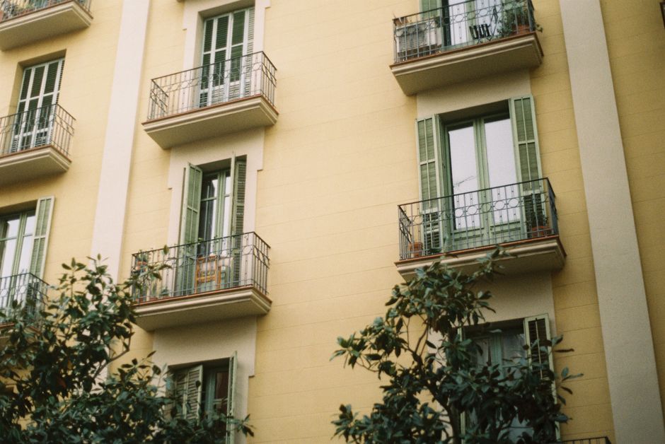 La fachada de un apartamento antiguo de Barcelona, con balcones clásicos y contraventanas verdes.