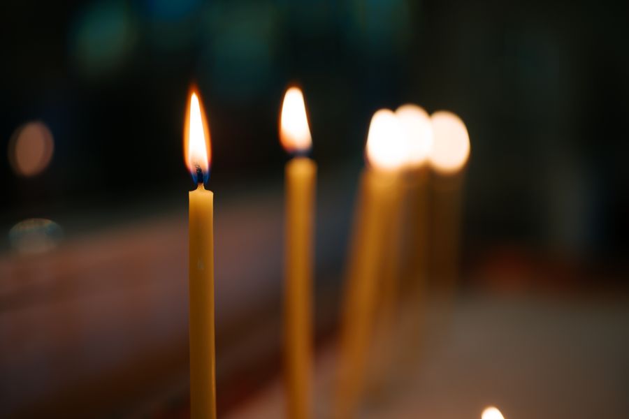 Lit memorial candles glowing warmly in soft focus