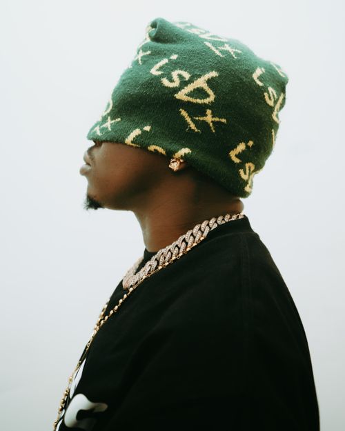 Free Side profile of a man wearing a green beanie and gold chain. Stock Photo