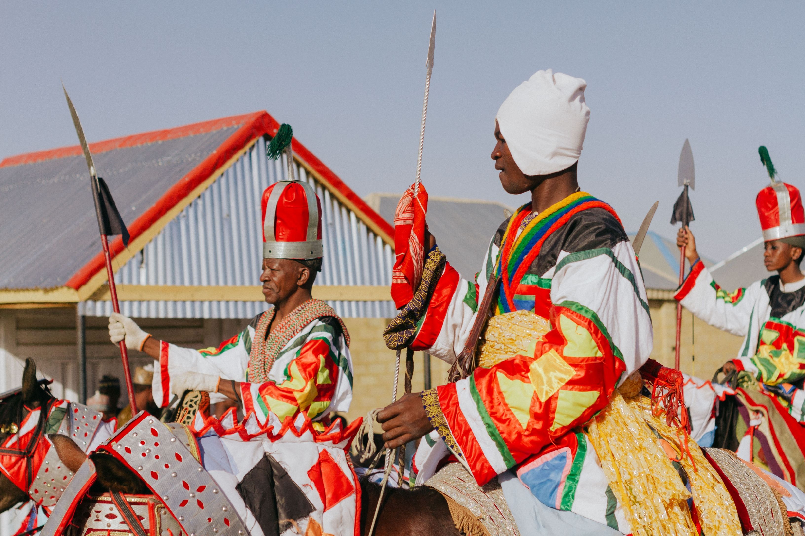 African horsemen in vibrant costumes participating in a traditional parade.