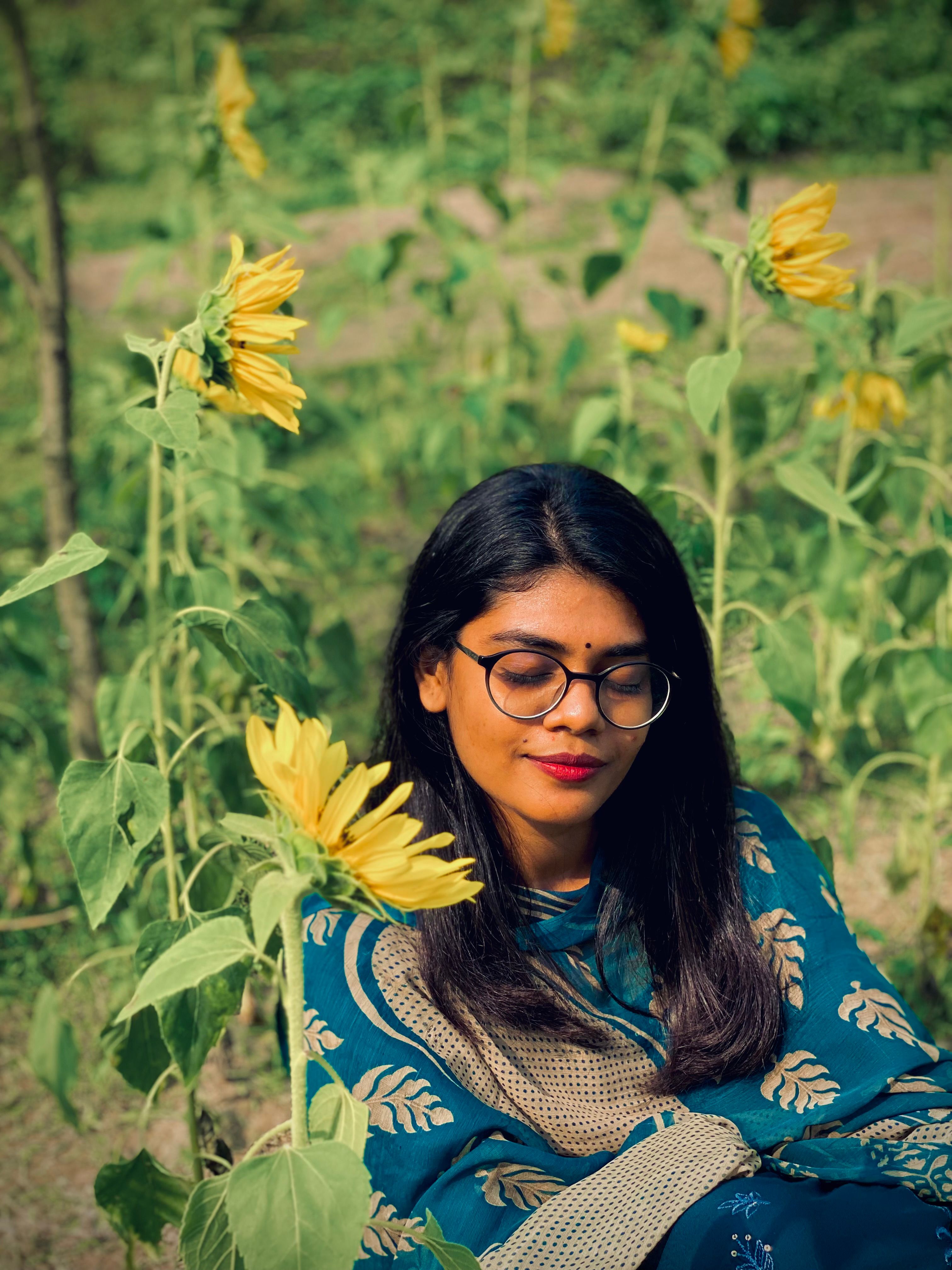 A serene portrait of a woman surrounded by sunflowers, embodying tranquility and nature's beauty.