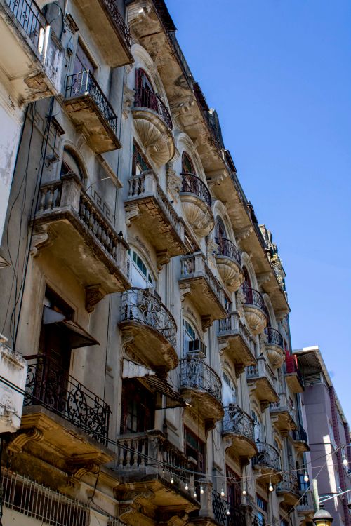 Free Close-up of a historic building's weathered facade with ornate balconies in daylight. Stock Photo