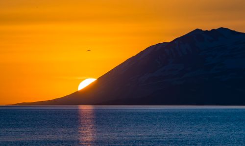 Free Stunning sunset view over an Icelandic mountain with ocean reflections. Stock Photo