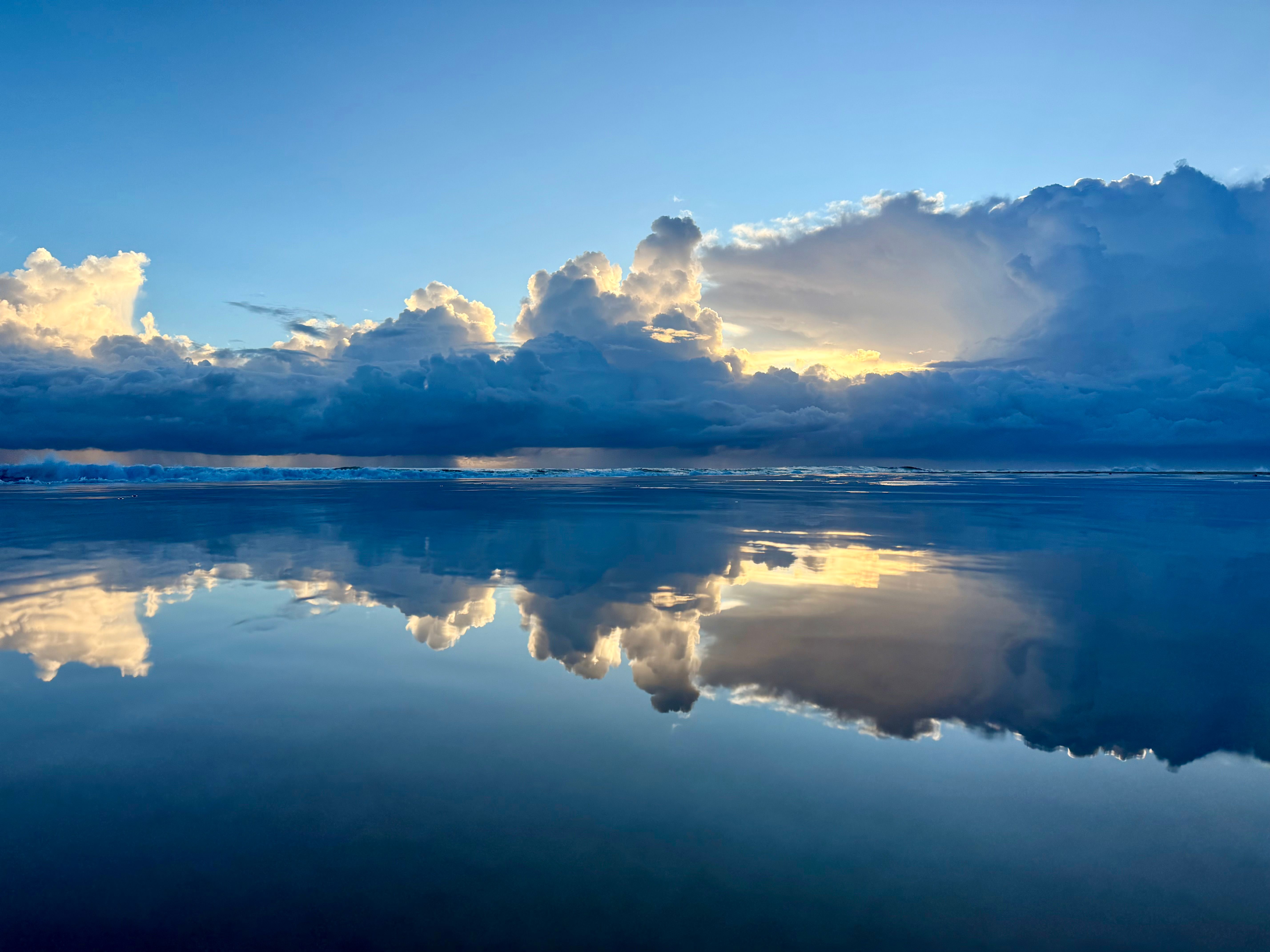 Dramatic Cloud Reflections Over Tranquil Ocean · Free Stock Photo