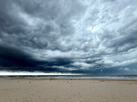 Captivating scene of storm clouds gathering over a deserted beach, hinting at an impending storm.
