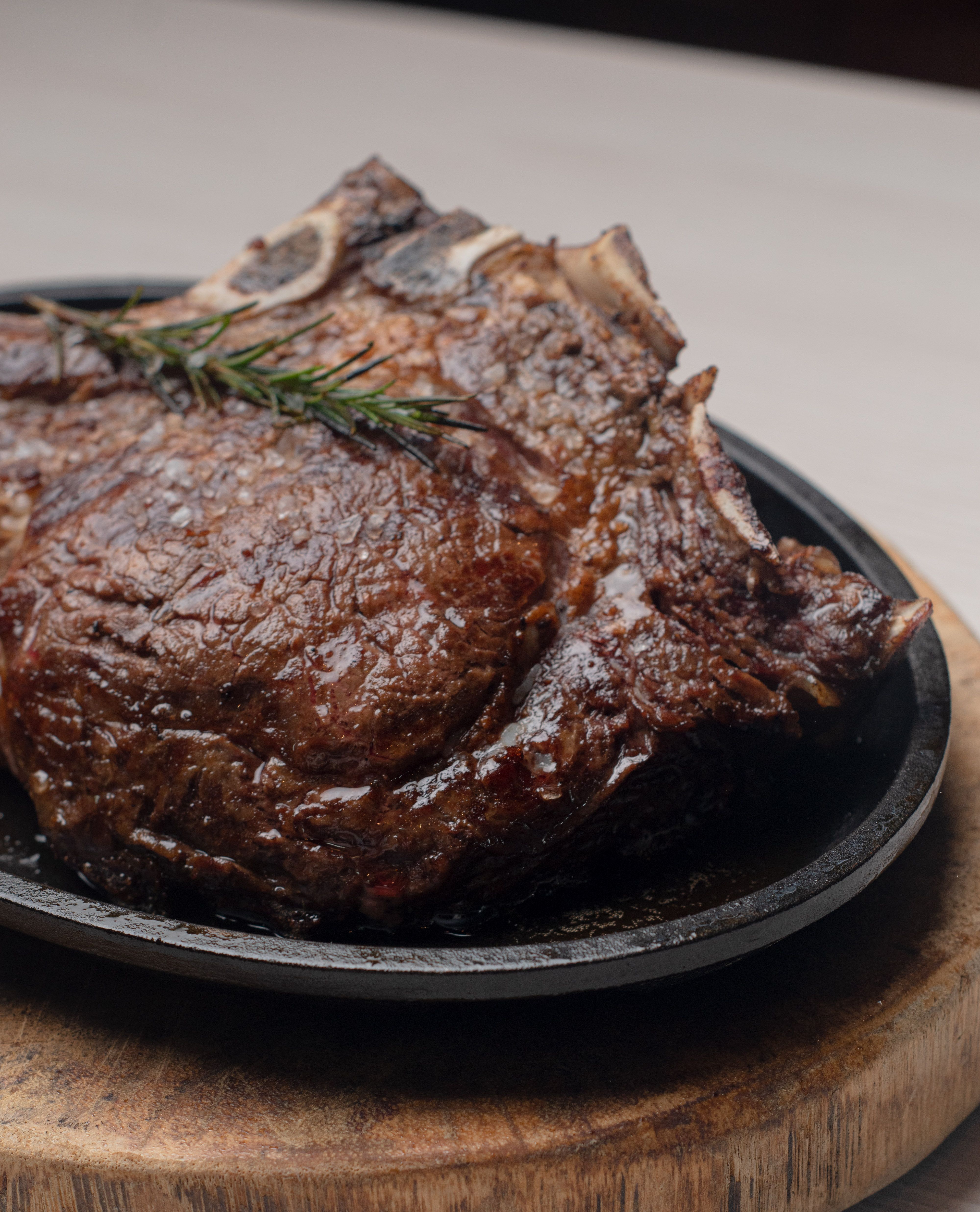 Close-up of a juicy grilled steak with rosemary, perfect for a gourmet meal.
