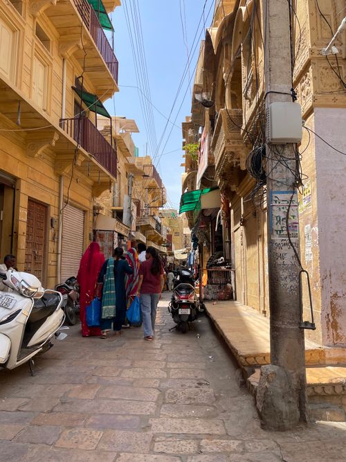 Free Vibrant street life in Jaisalmer with traditional architecture and locals in colorful attire. Stock Photo