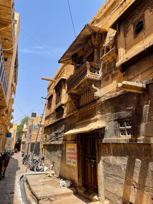 Free Experience the rustic charm of Jaisalmer's historic architecture along a sunlit street. Stock Photo