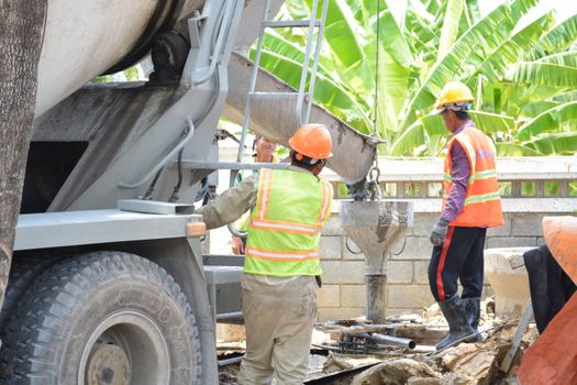 Photo by SÀI GÒN CÔNG TY CP SẢN XUẤT - THƯƠNG MẠI Construction site with workers pouring concrete from a truck chute outdoors.