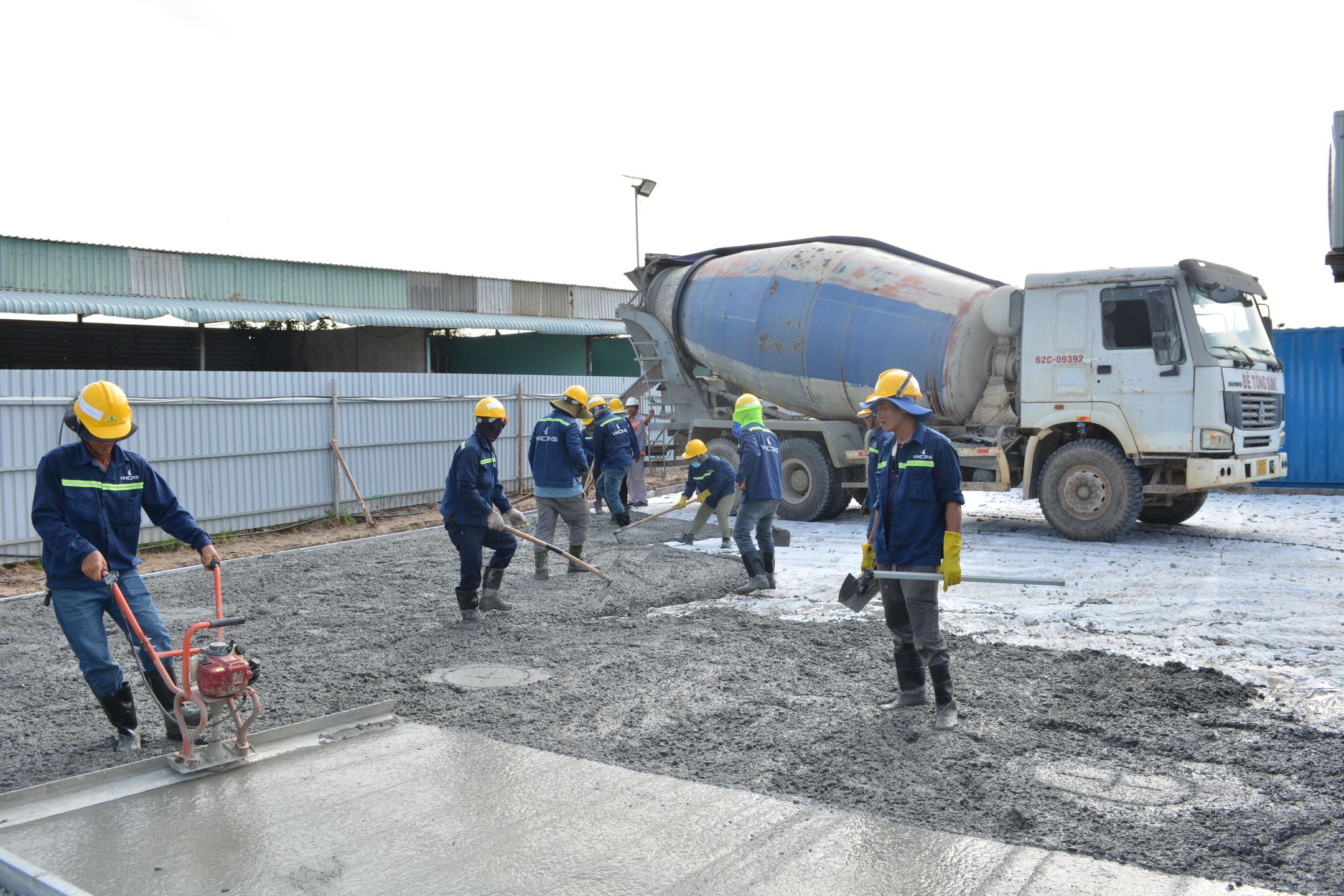 Crew pouring concrete next to a mixer truck