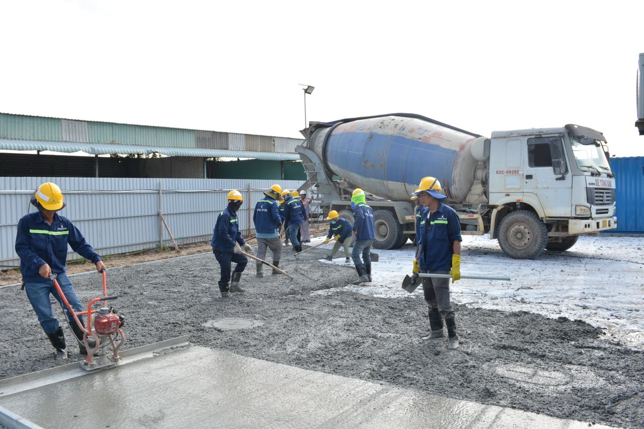 Concrete crew pouring and leveling fresh concrete on an outdoor job site