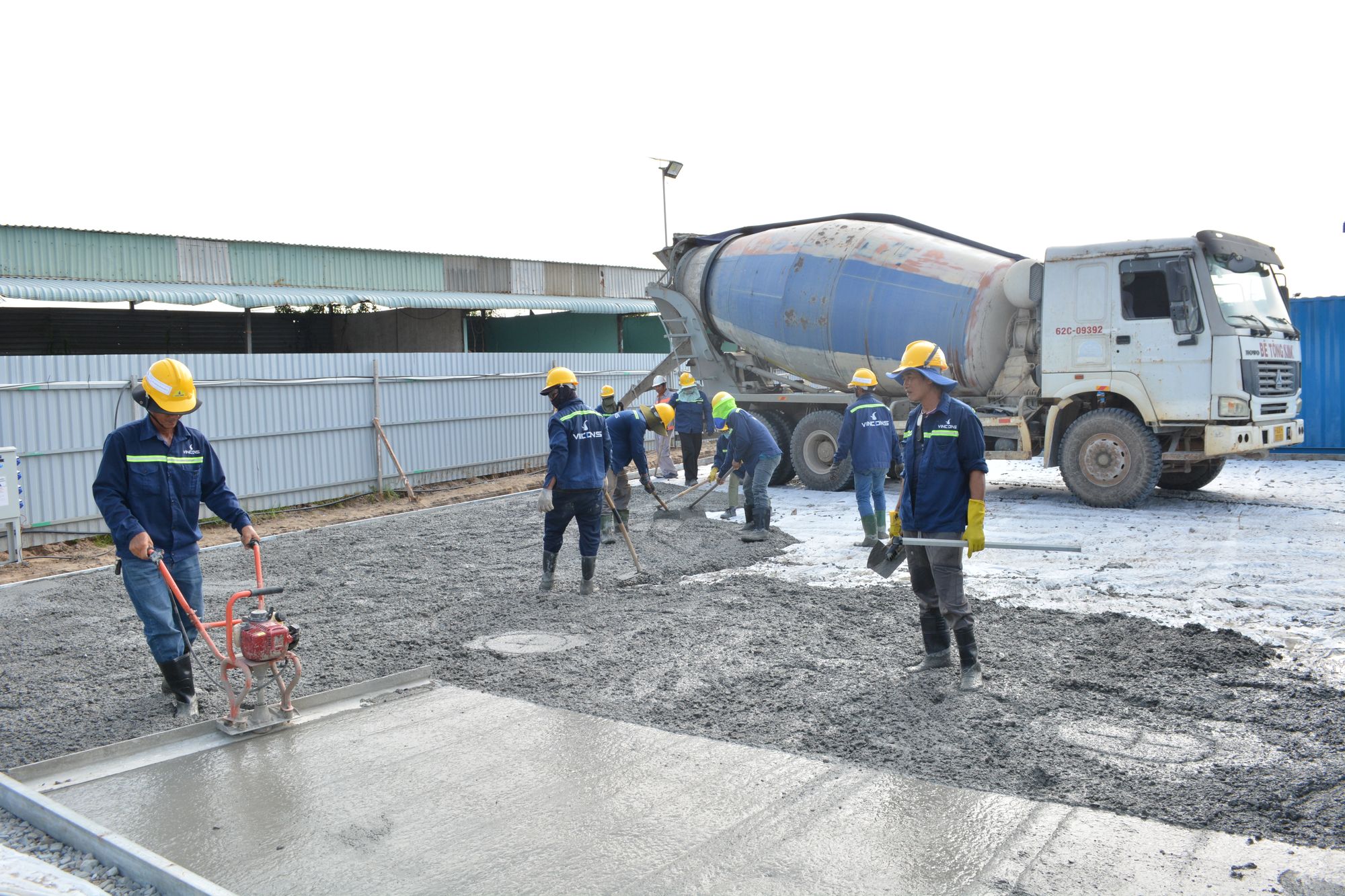 Crew placing concrete from a mixer truck across a commercial pour