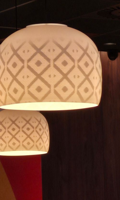 Free Stylish geometric lamp shades casting warm light indoors, perfect for modern design settings. Stock Photo