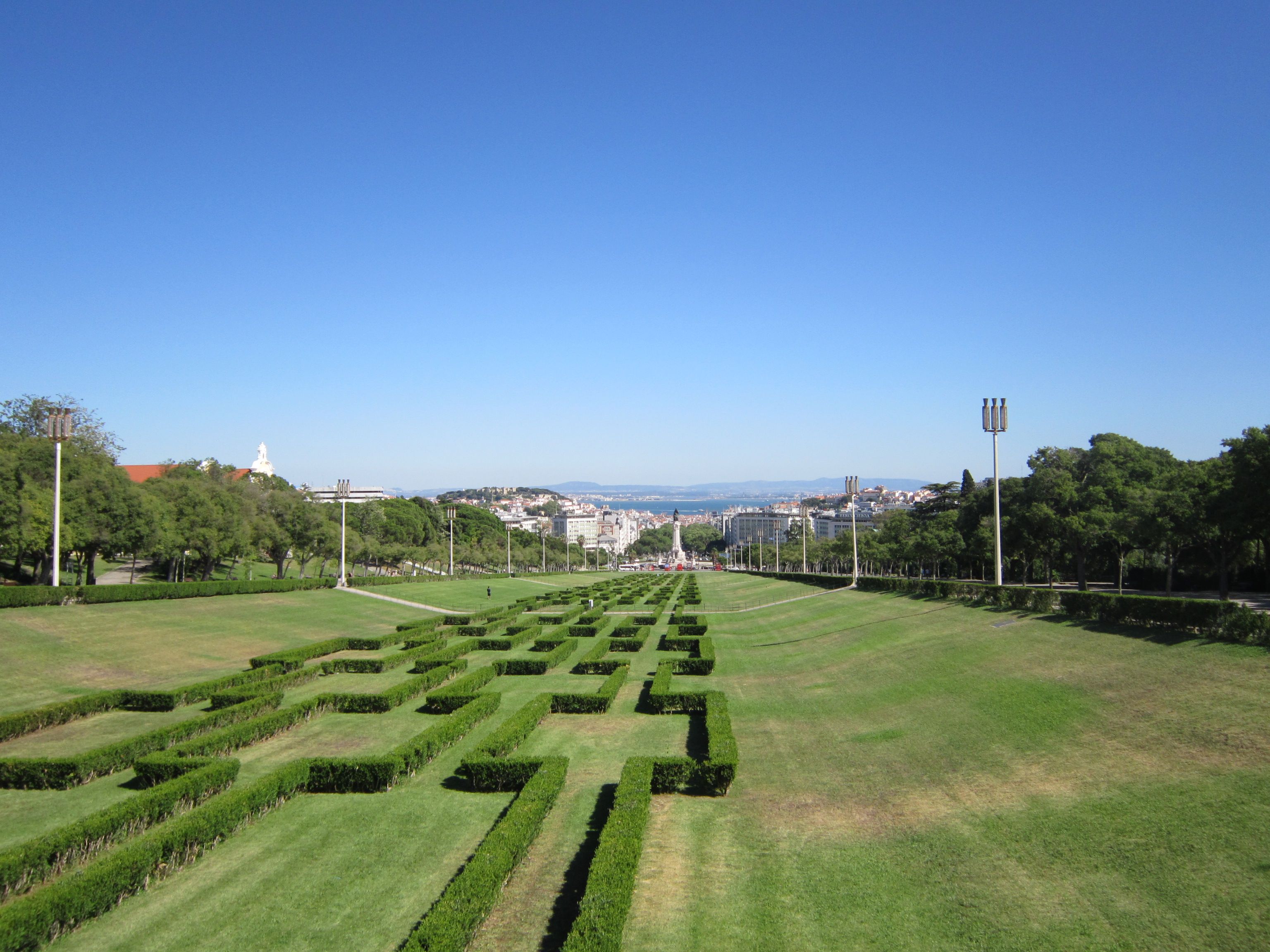 Clipped box hedges of Parque Eduardo VII running downhill toward Avenida da Liberdade and the Tagus
