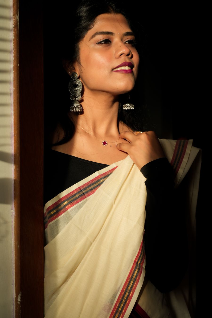 Elegant woman in a simple saree wearing visible statement earrings