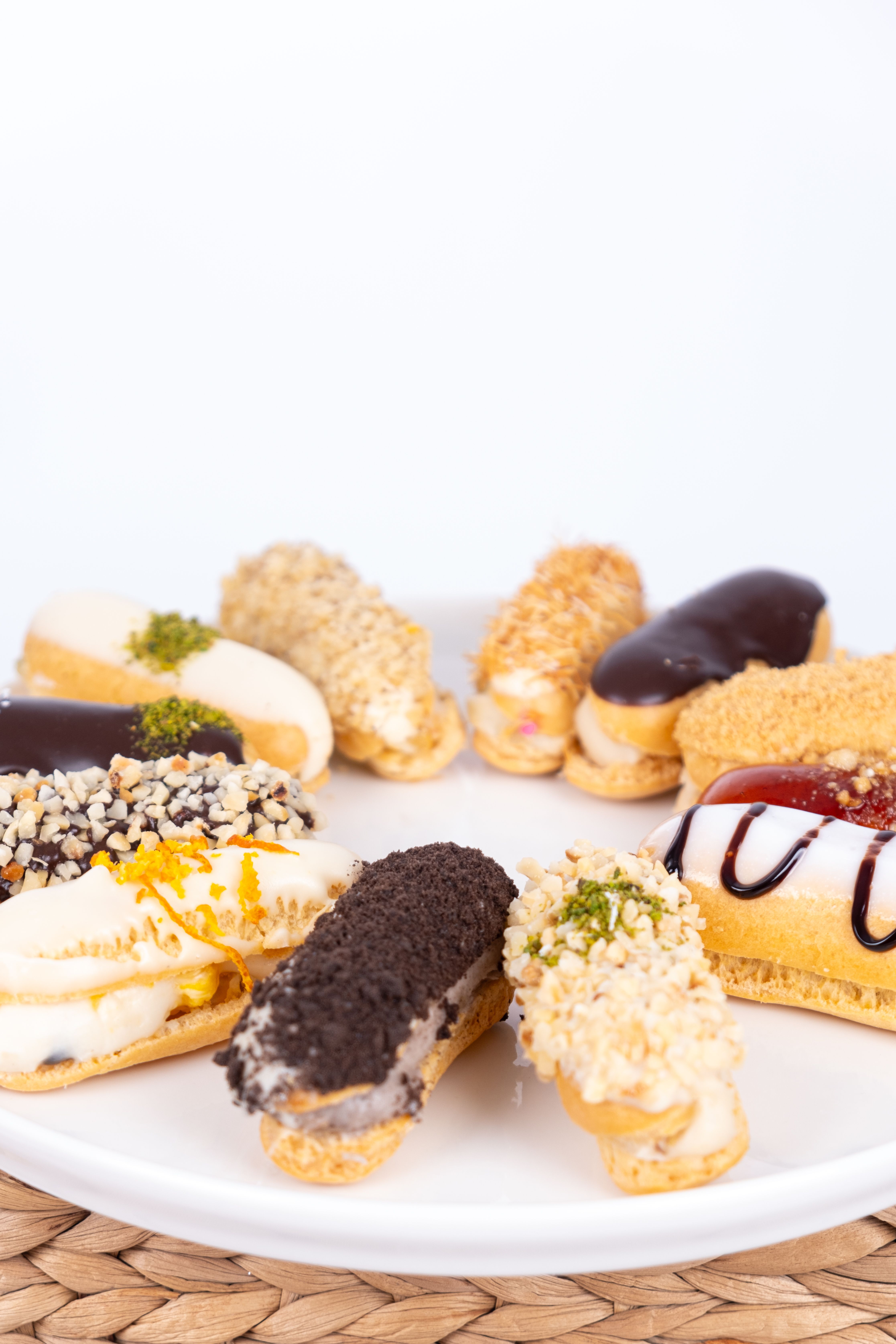 A selection of colorful gourmet eclairs arranged on a white plate.