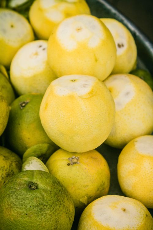 Free Close-up of freshly harvested citrus fruits with vibrant yellow and green hues. Stock Photo