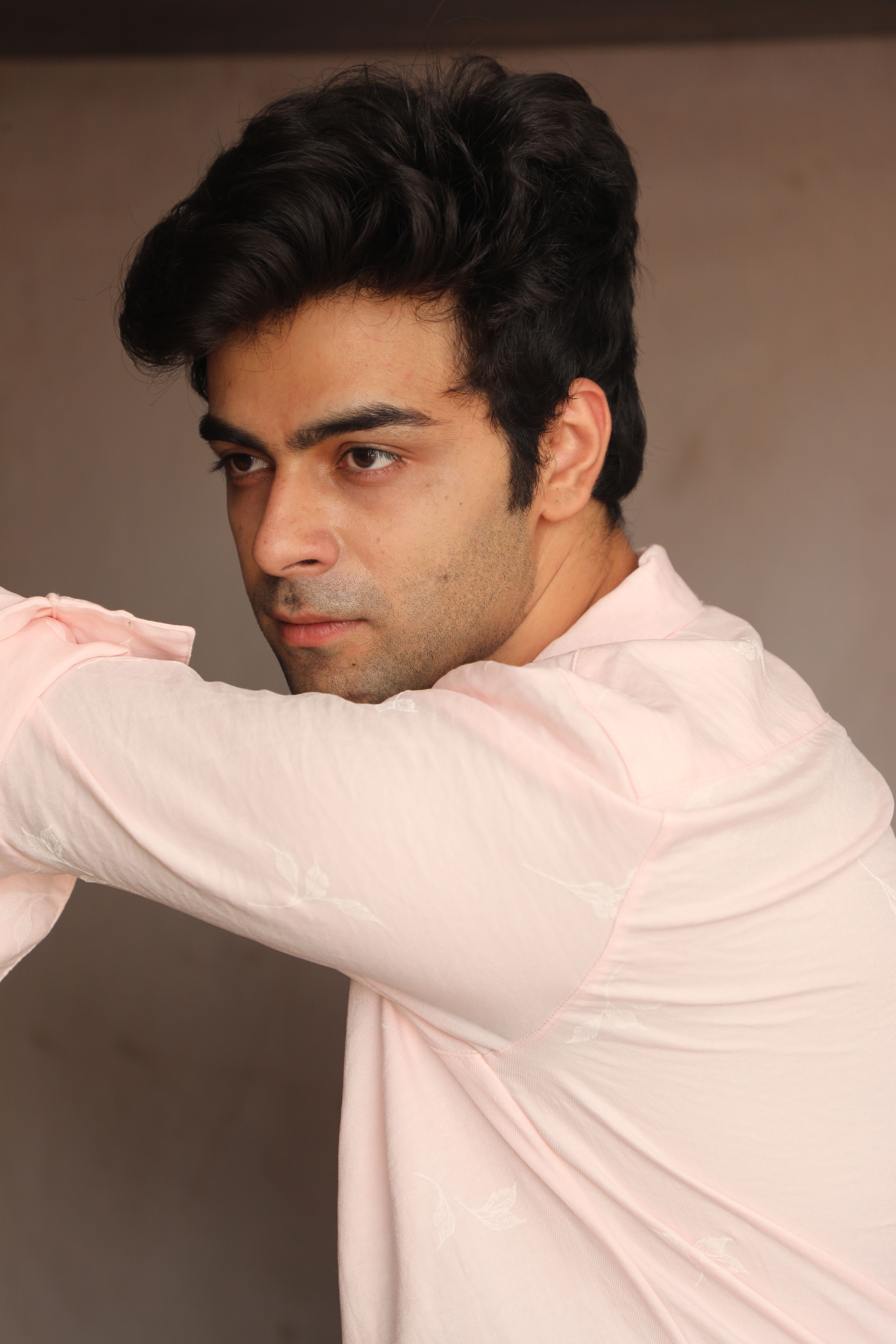 Portrait of a young man looking away with thoughtful expression indoors.