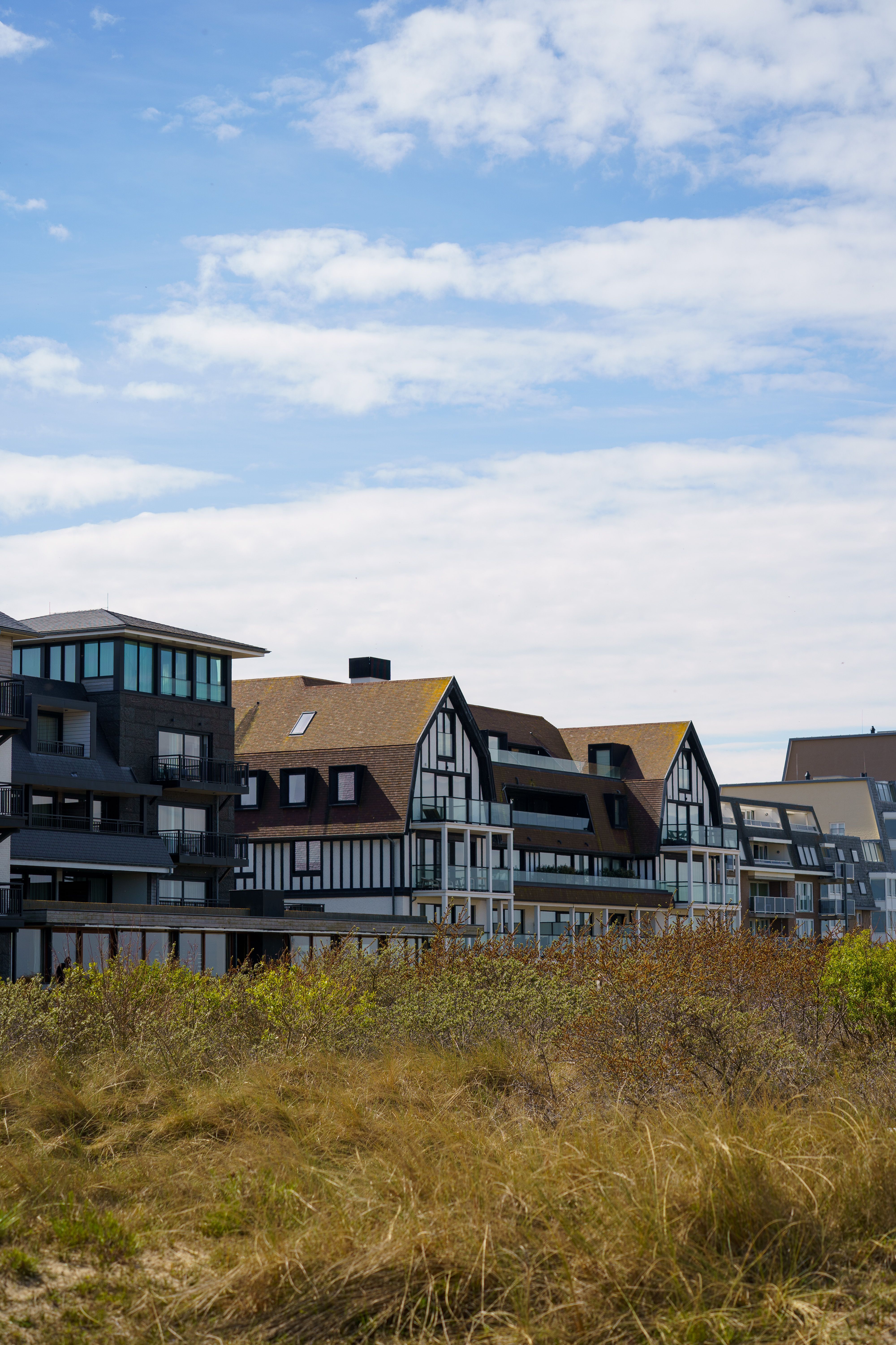 Gratuit Bâtiments contemporains en bord de mer à Cadzand, aux Pays-Bas, se détachant sur un ciel bleu. Photos