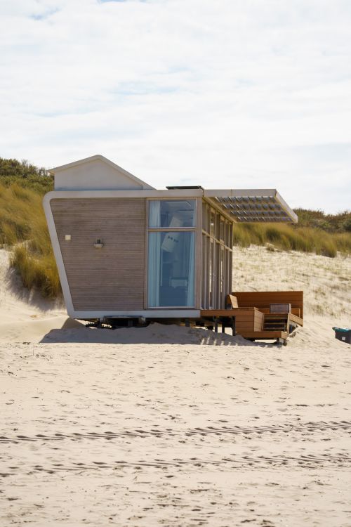 Free Contemporary wooden beach house situated on sandy dunes in Cadzand, Netherlands, under a clear sky. Stock Photo