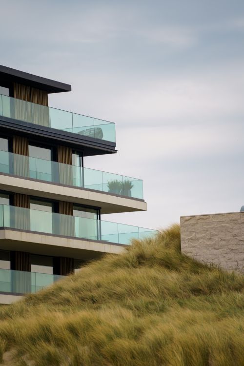 Free Contemporary building with glass balconies near sand dunes in Cadzand, Netherlands. Stock Photo