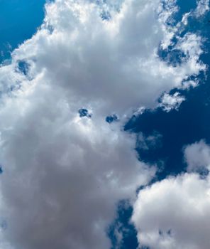 Beautiful bright white clouds floating in a clear blue sky on a sunny day.