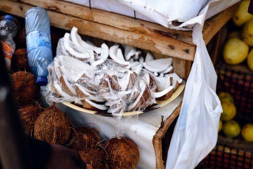 Free Coconut slices and whole nuts on display at an outdoor market in Jos, Nigeria. Stock Photo