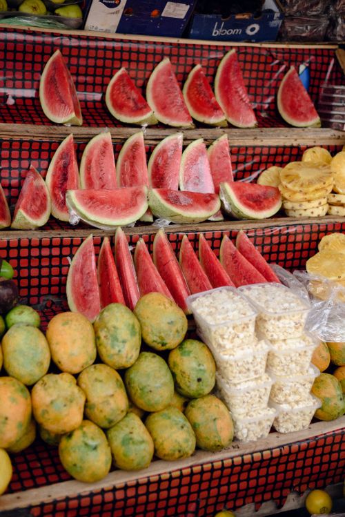 Free Vibrant display of fresh watermelon, mangoes, and pineapple at a Jos market stall. Stock Photo