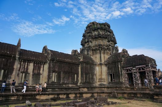 A stunning capture of the ancient Angkor Wat temple with tourists exploring its historic architecture.