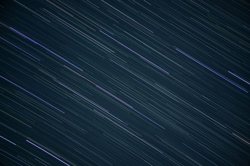 Free Captivating long exposure of star trails creating streaks in the night sky. Stock Photo
