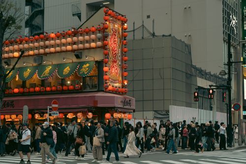 Free A lively street in Tokyo's Shinjuku with illuminated signs and crowds crossing. Stock Photo