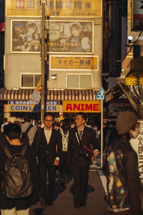 Free Crowded street in Tokyo with business people and anime signs in warm daylight. Stock Photo