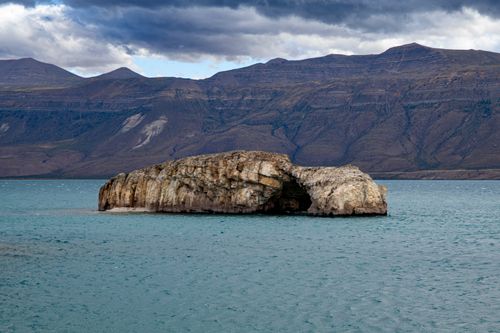 Free Majestic rock formation in Lago Posadas, Argentina, with mountainous backdrop. Stock Photo