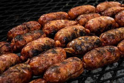 Close-up of flavorful grilled sausages sizzling on a barbecue grill.