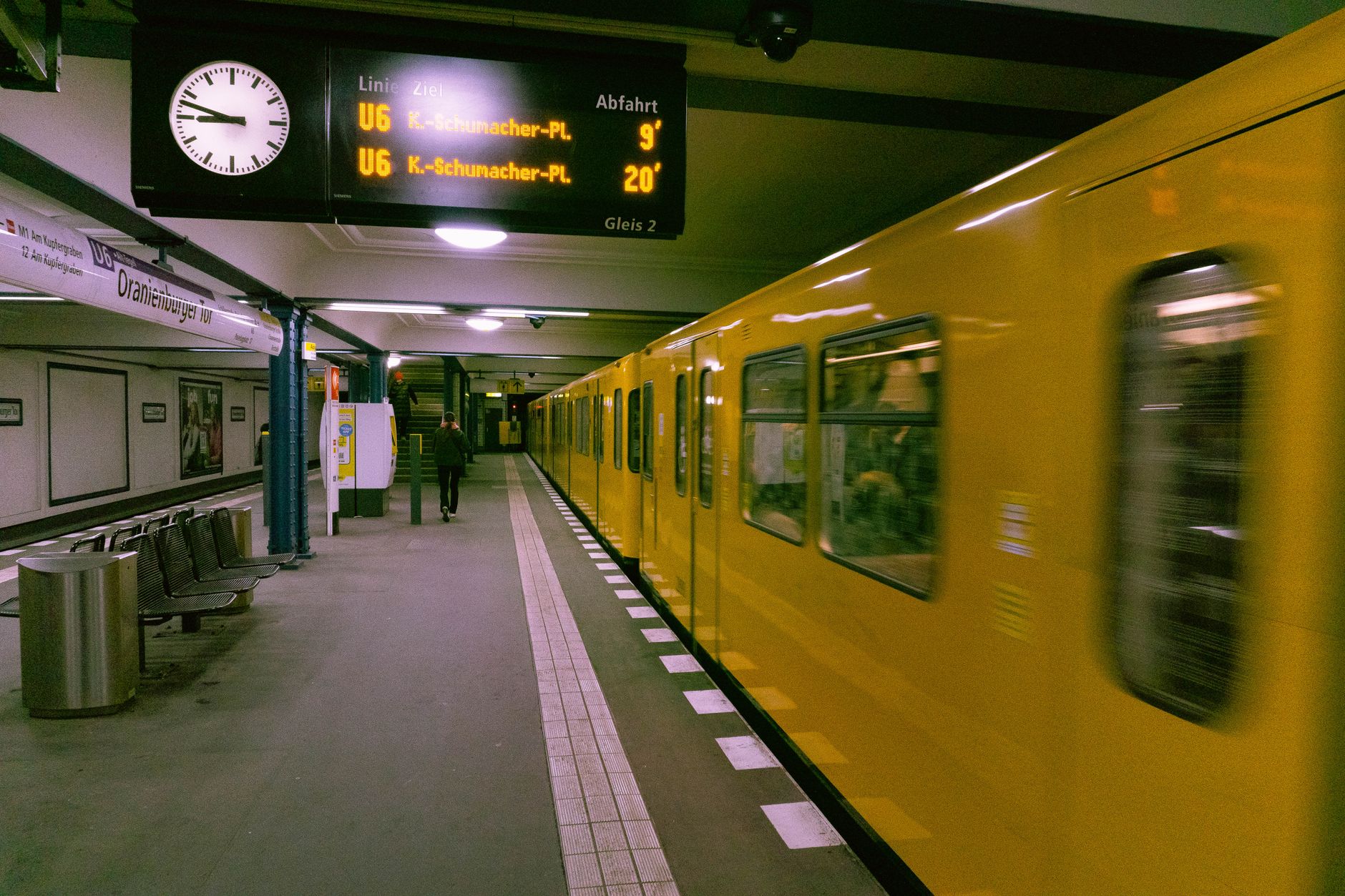 Yellow subway train in motion at Oranienburger Tor station, Berlin, Germany.