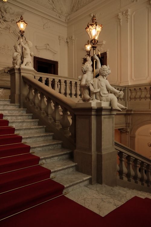 Free A grand staircase with ornate sculptures and vintage lamps in a historic Dresden building. Stock Photo