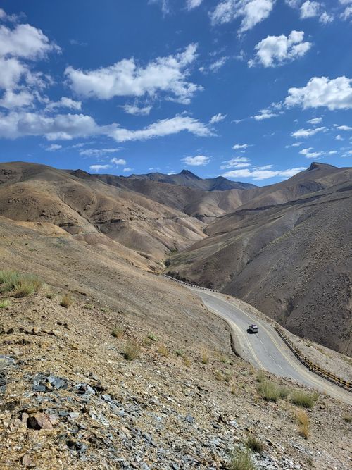 Free Winding road through barren Himalayan mountains under a clear blue sky. Stock Photo