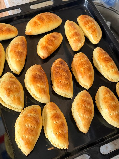Free Golden brown pastries baked to perfection, cooling on a tray, inviting a delightful taste experience. Stock Photo