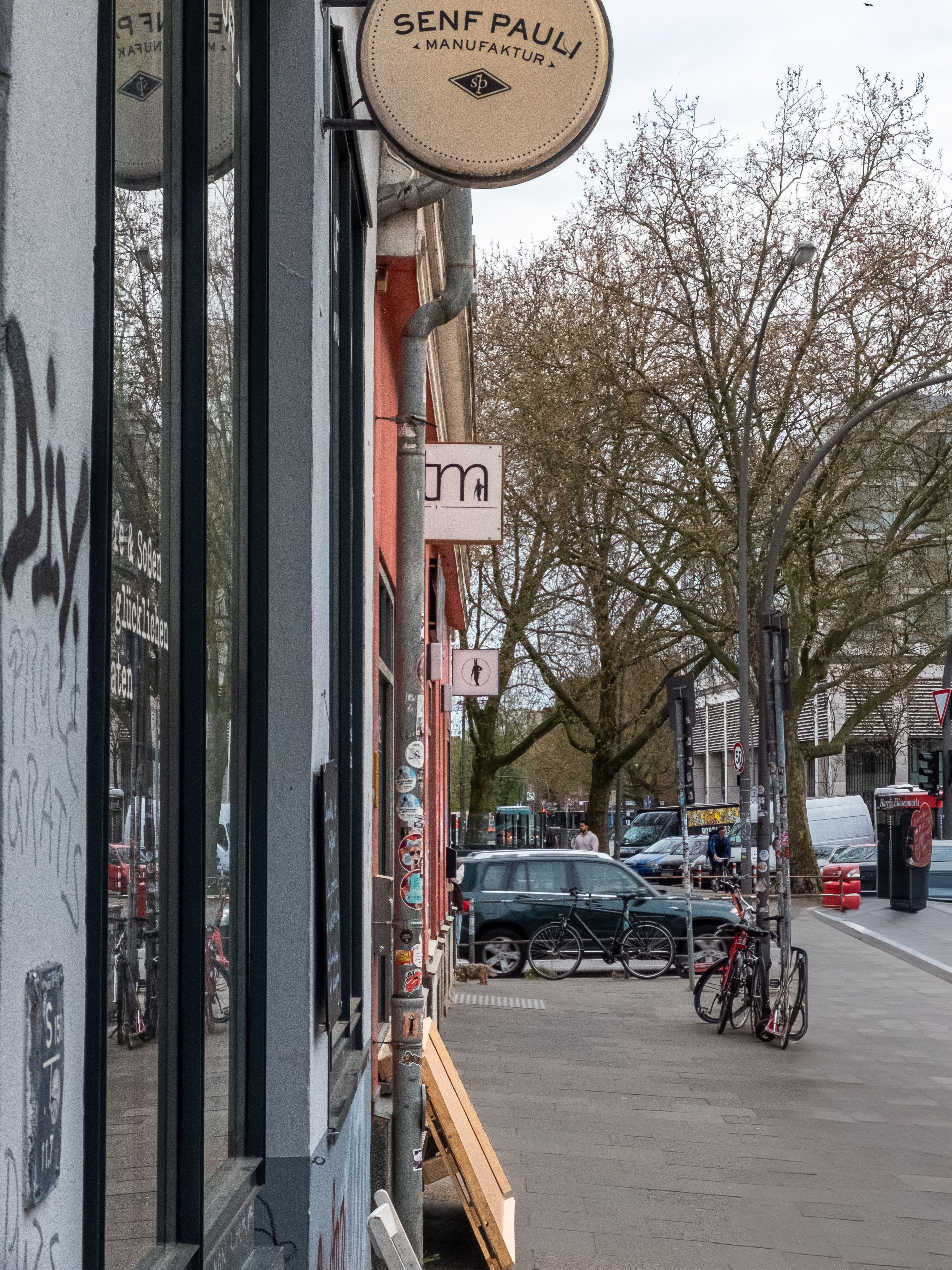 Urban street scene with bicycles and European architecture, featuring tree-lined avenue.