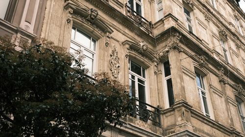 Free Elegant building facade with ornate decorations and large windows, capturing classic architectural style. Stock Photo