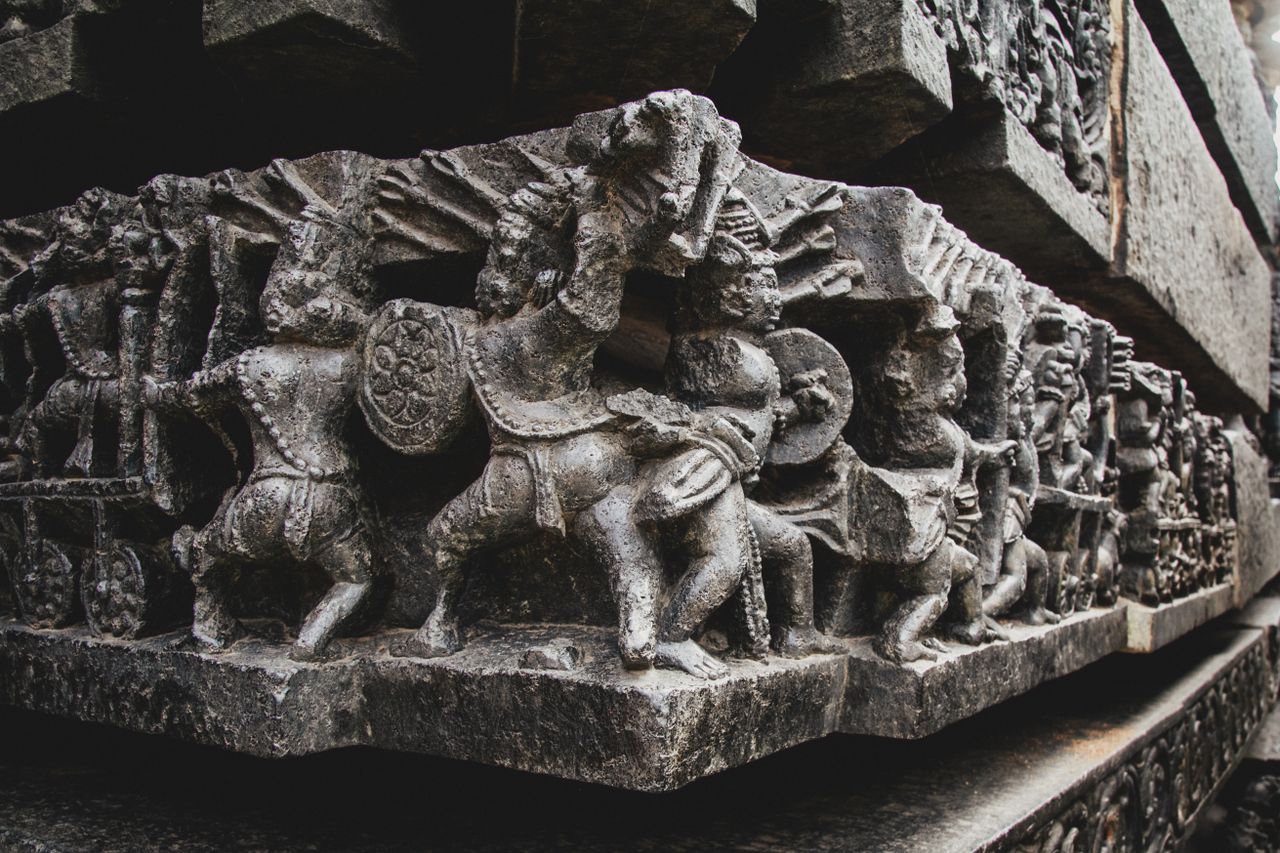 detailed stone carvings depicting historical scenes on a temple wall s