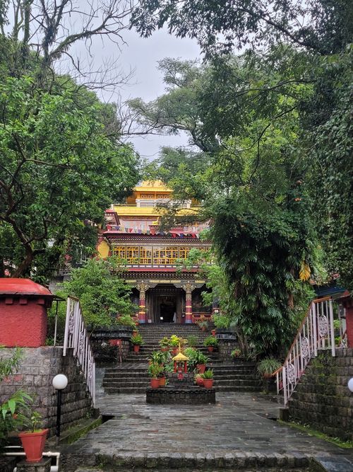Free Vibrant temple entrance surrounded by lush greenery, showcasing traditional architecture. Stock Photo