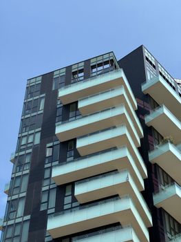 Contemporary residential building with glass balconies in Milan, Lombardy.
