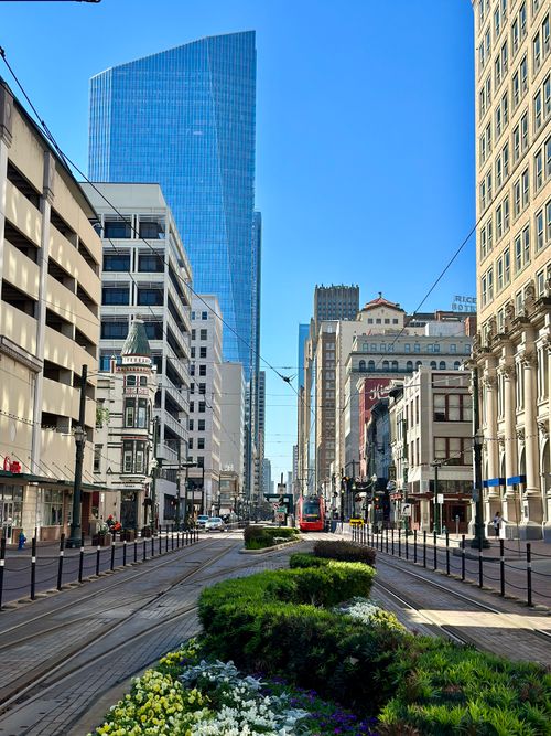 Free A vibrant view of downtown Houston featuring skyscrapers, a tram, and lush city landscaping under a clear blue sky. Stock Photo