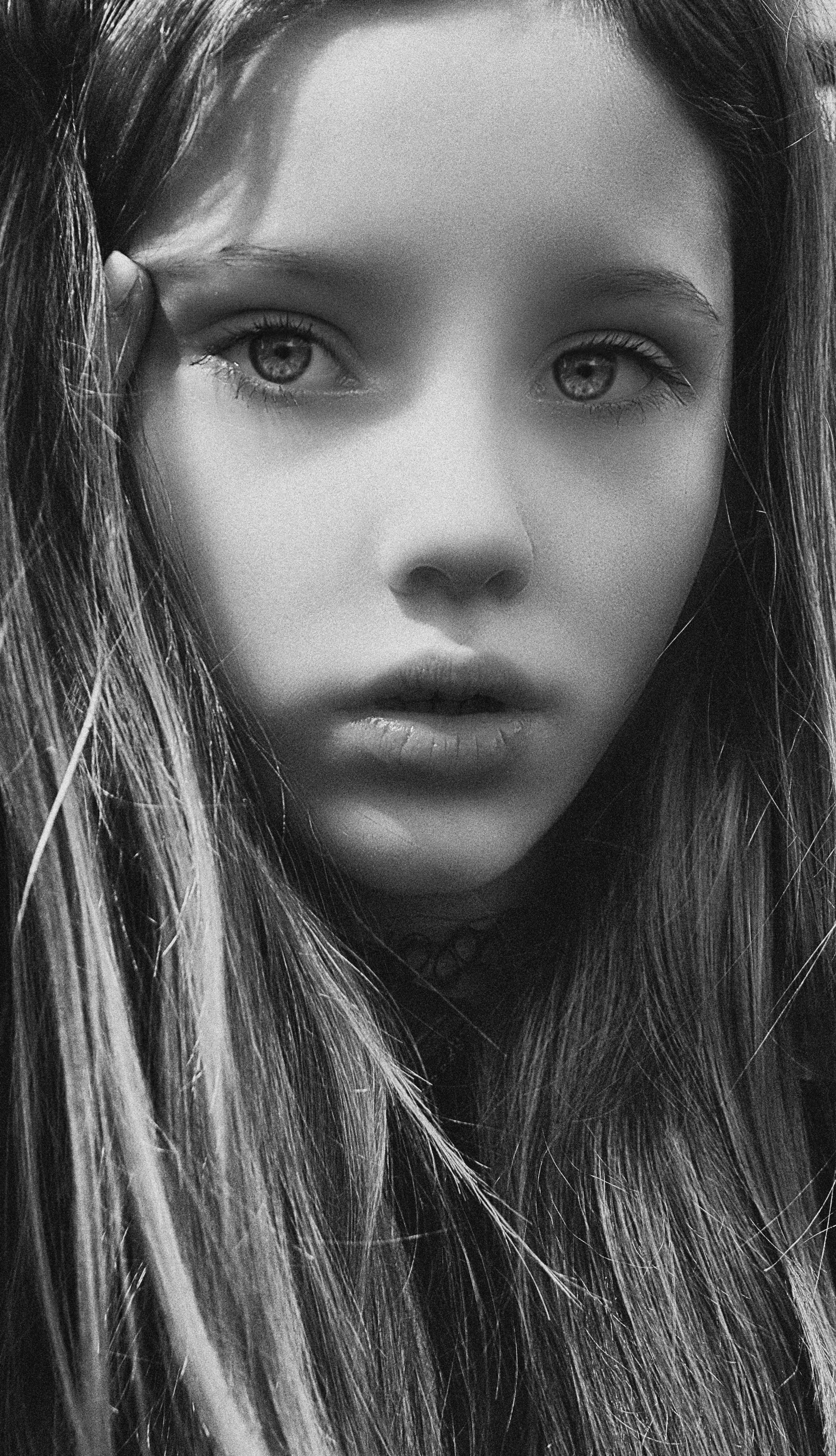 Captivating black and white portrait of a young girl with long hair.
