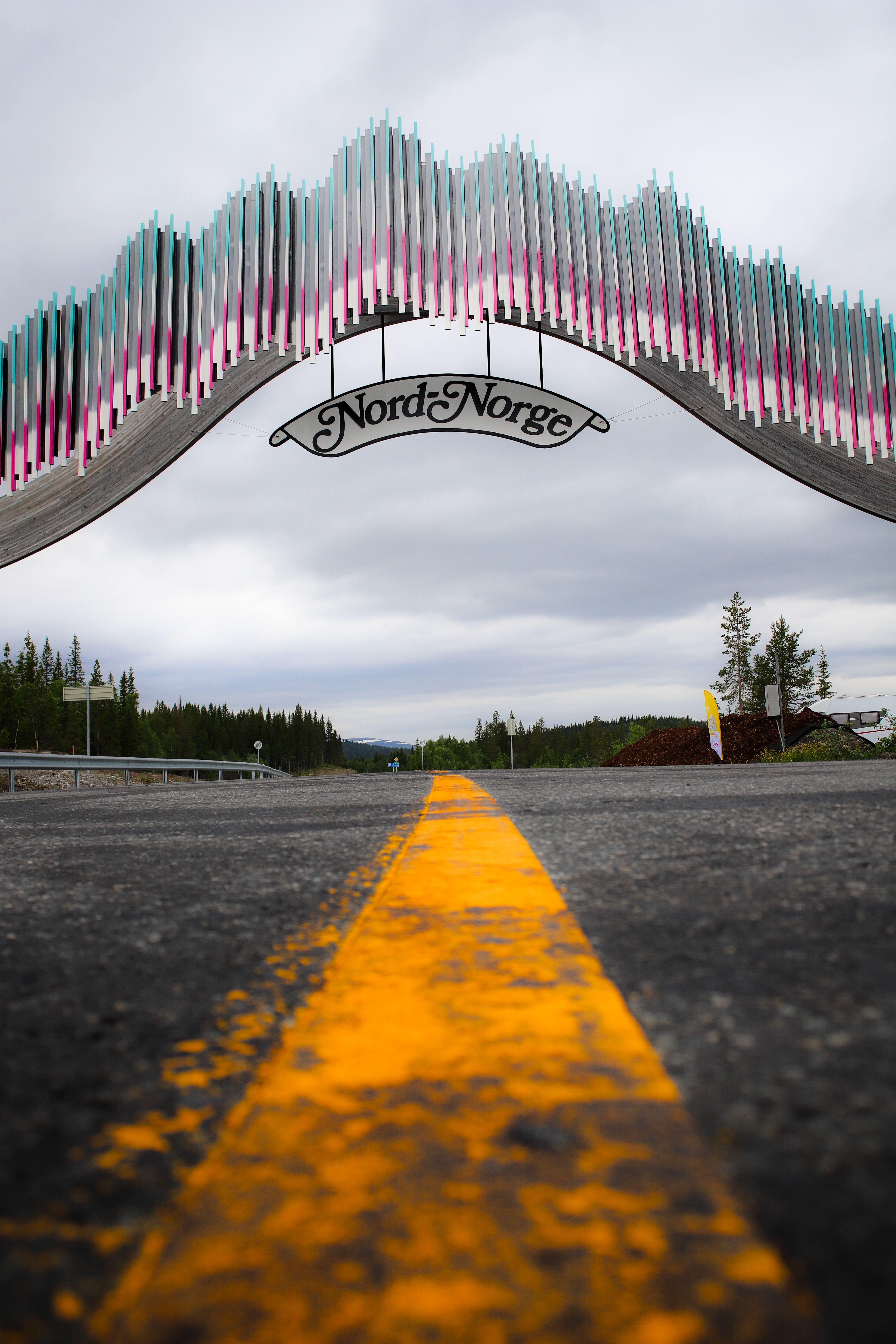 Dramatic view of the Nord Norge gateway arch on a scenic road in Norway.